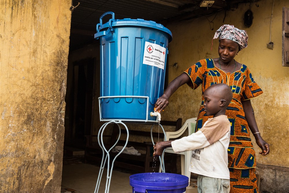 Сім'я вчив, як мити руки належним чином будинку під час спалаху Ебола. Фото UNMEER / Мартін Перре
