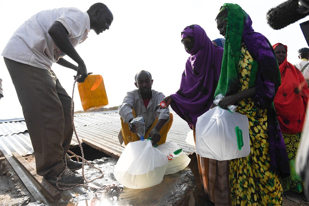 Women who were internally displaced by the ongoing drought in Somaliland receive water at a UNICEF-supported water distribution point in Laaca village near Gabiley, Somaliland. UN Photo/ Omar Abdisalan