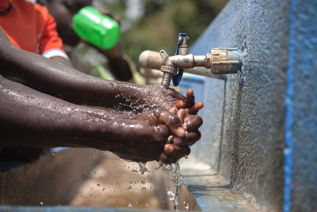 A pupil of Lokiel Primary School, Uganda washes her hands