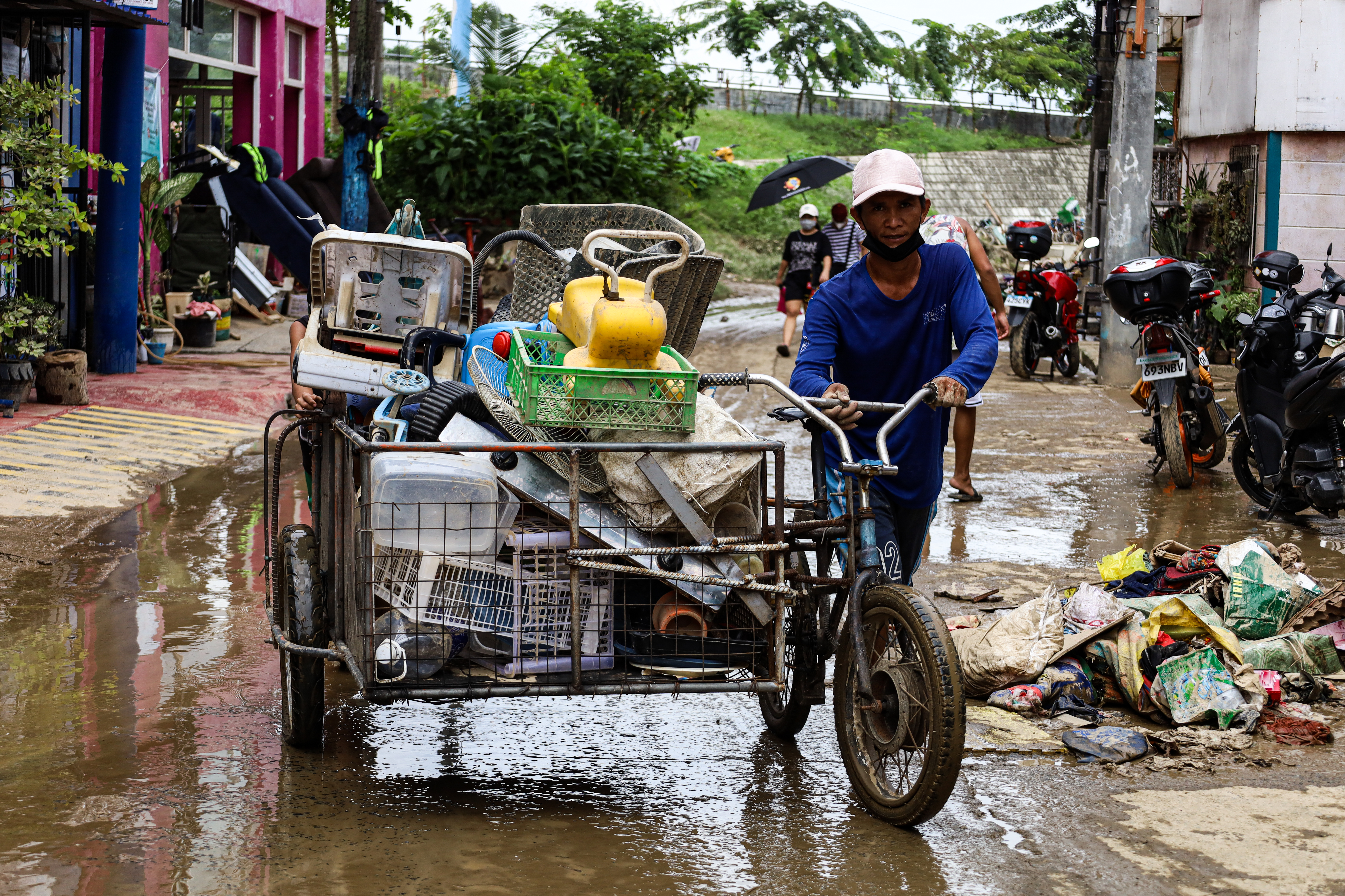 Man on bike with belongings in flooded street